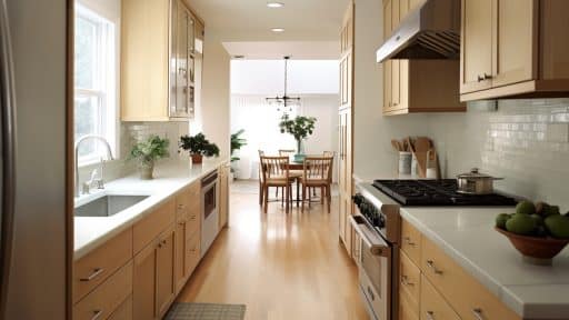 A imagem mostra uma cozinha com móveis planejados e design moderno, destacando os armários e bancadas funcionais e organizados.